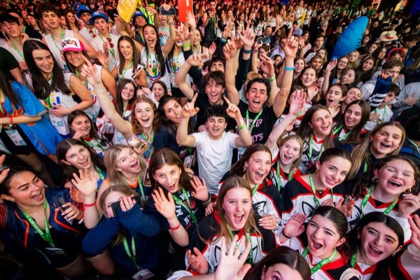 BBYO Centennial celebration with confetti, lights, and a crowd of attendees