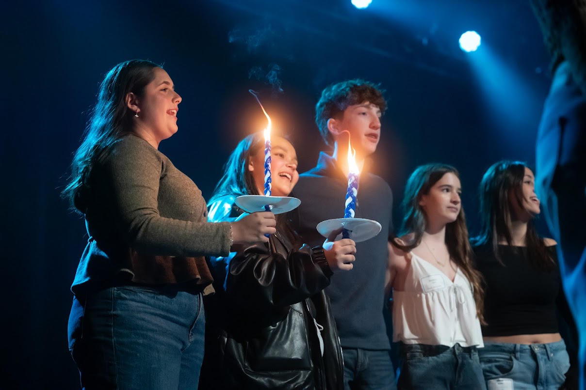 BBYO Centennial celebration with confetti, lights, and a crowd of attendees