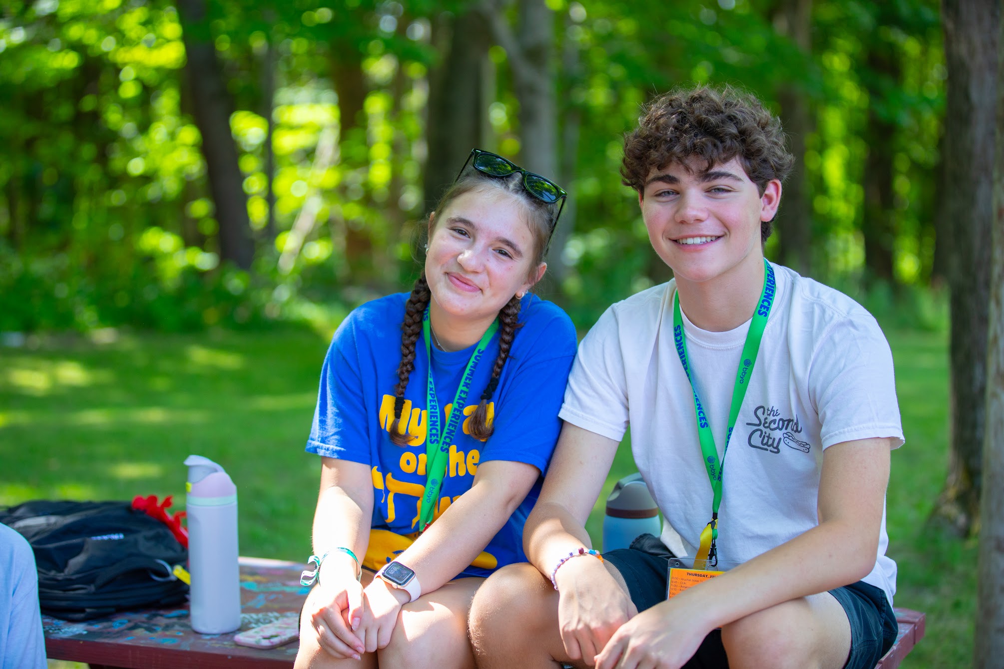 A diverse group of young adults jumping with excitement in a lush green garden during a community event.